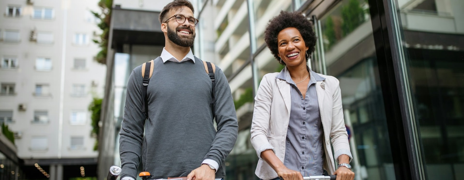a man and a woman holding a scooter and a bike